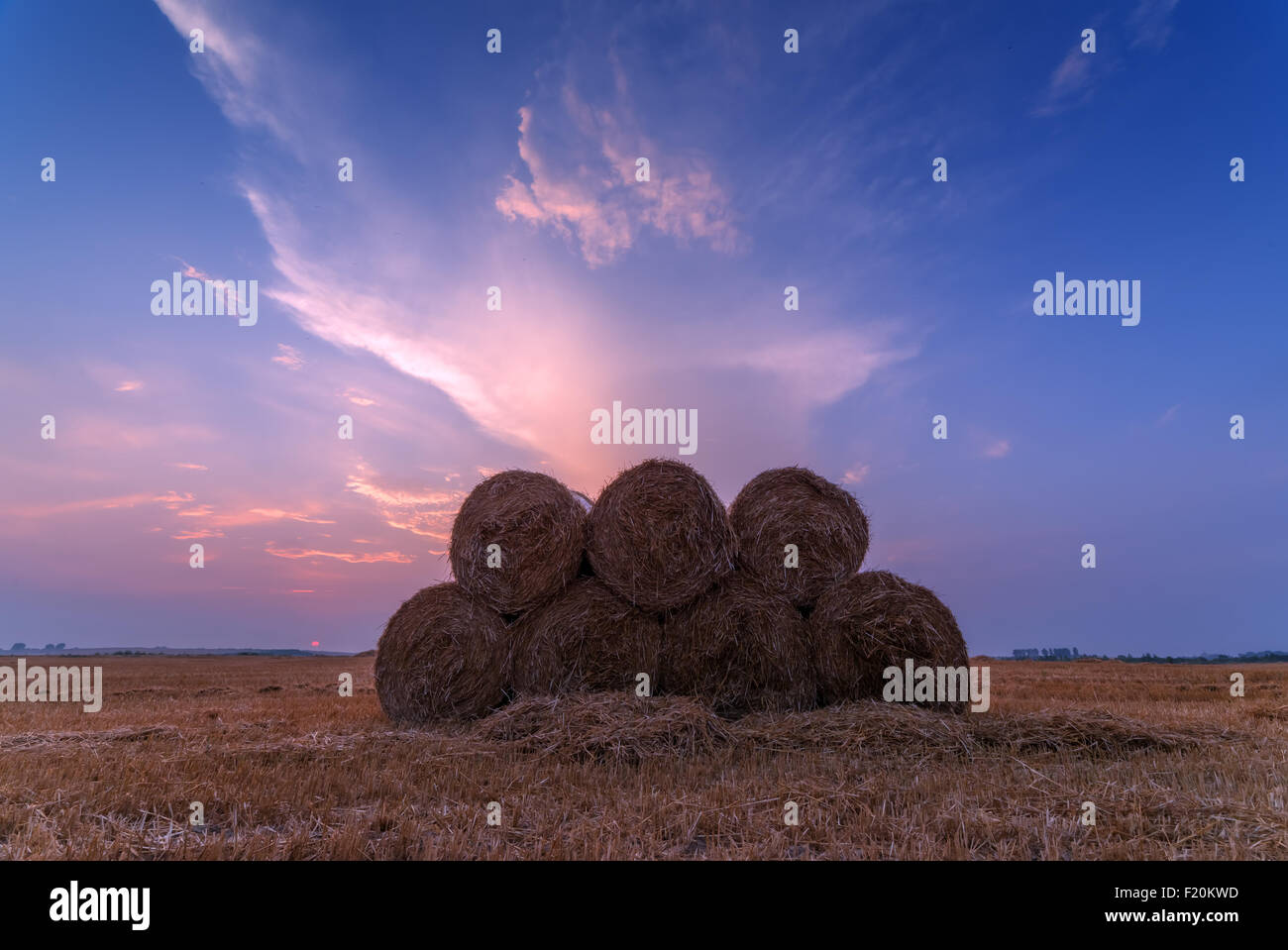 Erstaunliche Ländliches Motiv auf Herbst Feld mit Stroh Rollen und dramatische Abendlicht. Stockfoto