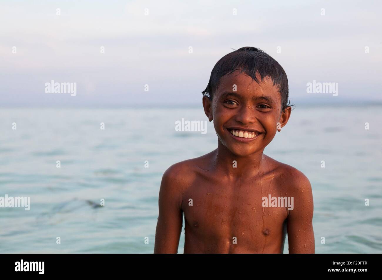 Indonesien, Maluku Provinz, East Seram Koon Island, Kind Lächeln im Wasser Stockfoto