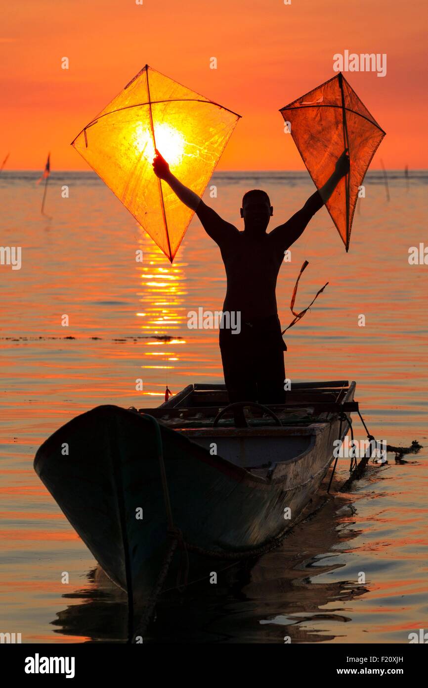 Indonesien, kleinen Sunda-Inseln, Alor Archipel Insel Pantar, Kabir, Fischer hält stolz seine Fischerei Drachen im Sonnenuntergang, Kabir Village, Pantar Insel Alor, Nusa Tenggara Timor, Indonesien Stockfoto