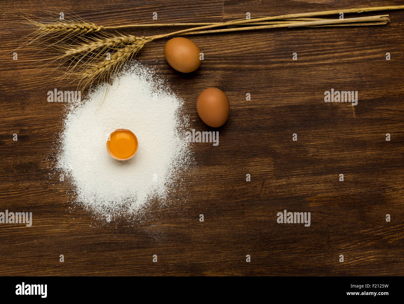 Mehl und Eiern auf einem Holzbrett Stockfoto