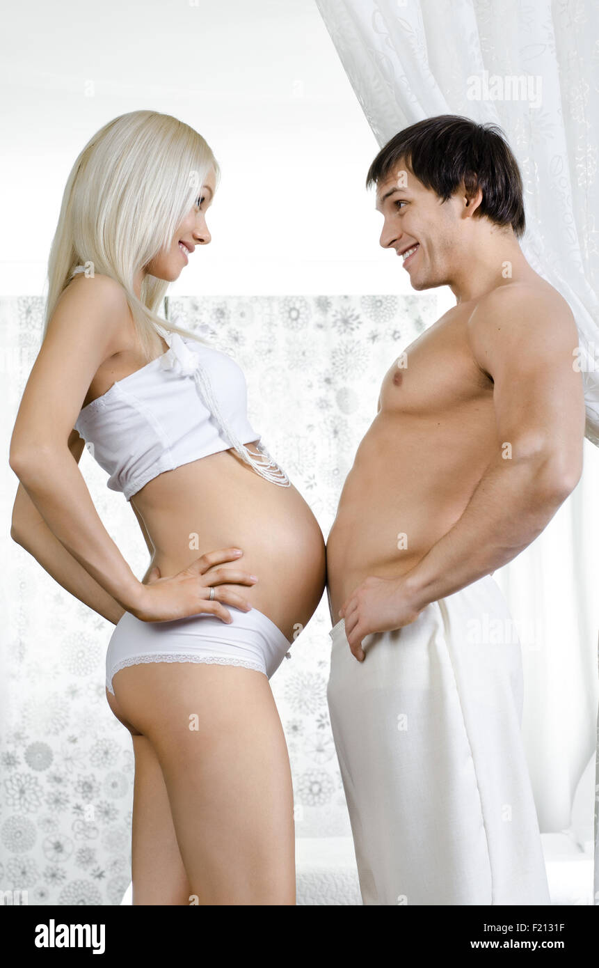 glückliche junge schwangere Frau mit Mann im Hause Lichtraum Stockfoto