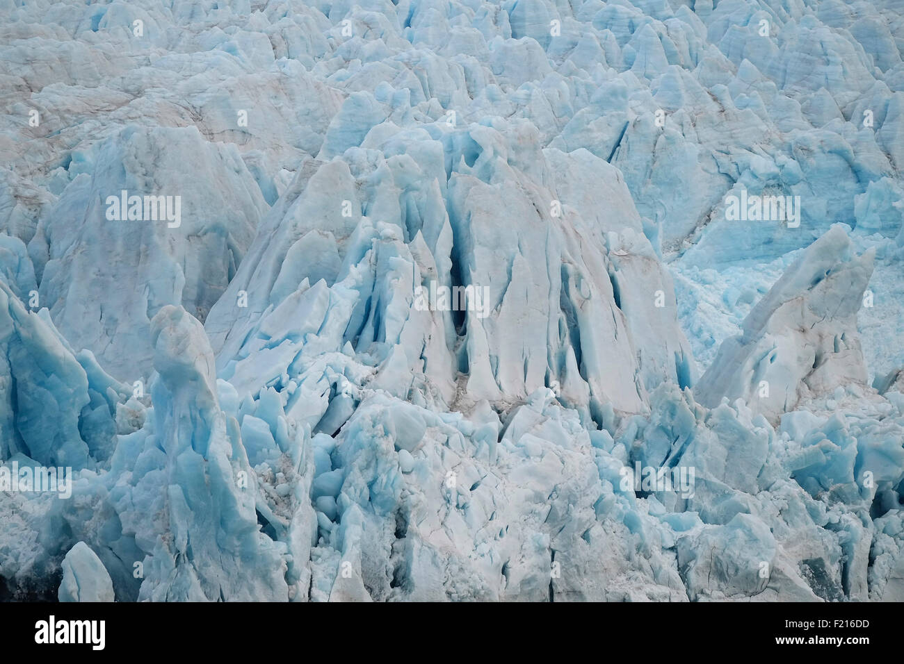 Norwegen, Spitzbergen, Nordenskiöld Gletscher, blaue Eis Eis getragen Felsvorsprung, Gletscherfront bereit, Eis in den Fjord zu kalben. Stockfoto