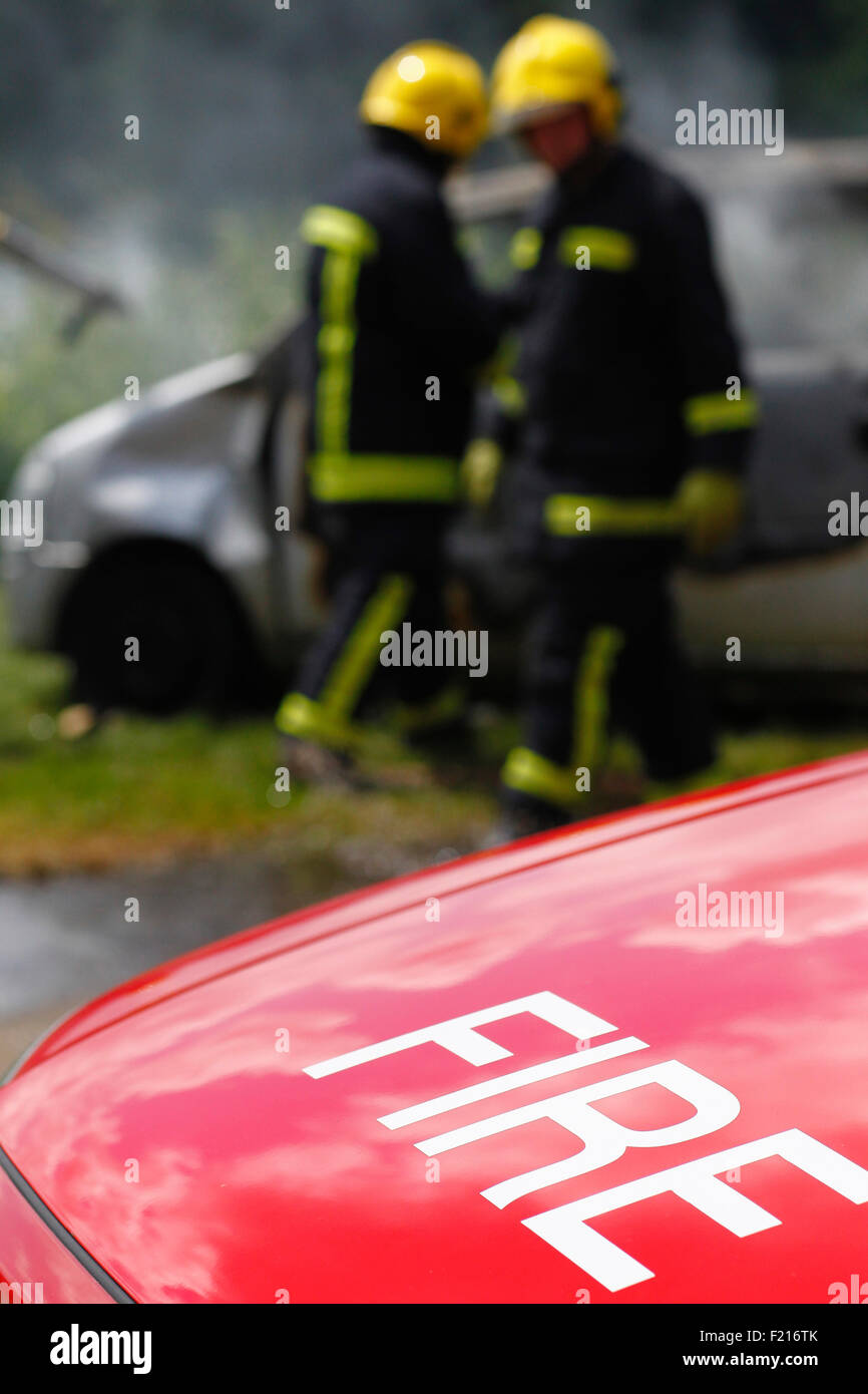 Grundversorgung, Feuerwehrleute, Feuer in ein Auto setzen. Stockfoto