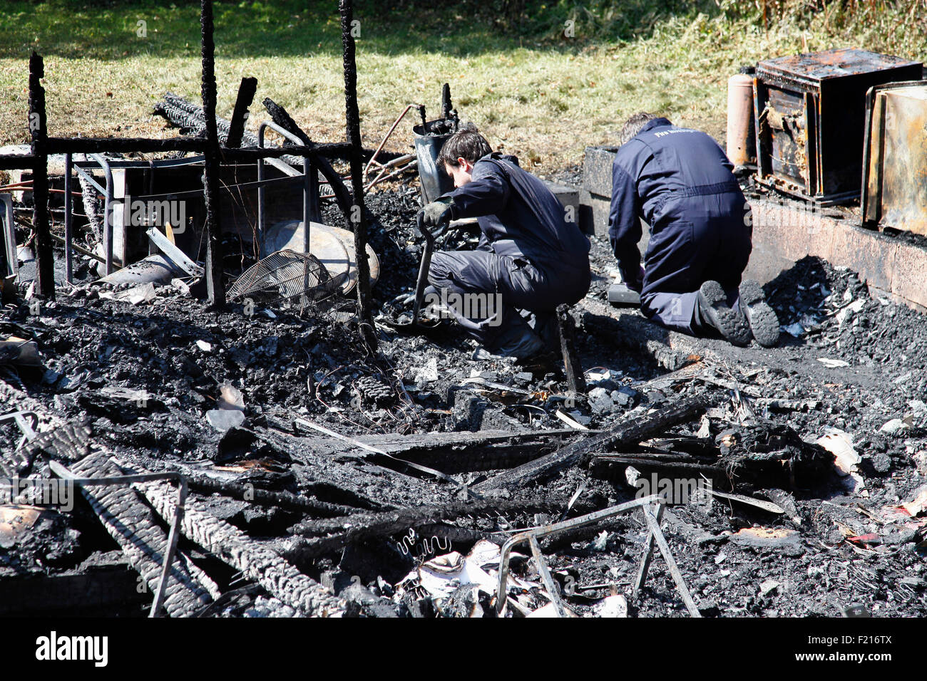 Grundversorgung, Feuer, forensische team Examing verkohlten Ruine für mögliche Ursachen des Feuers. Stockfoto