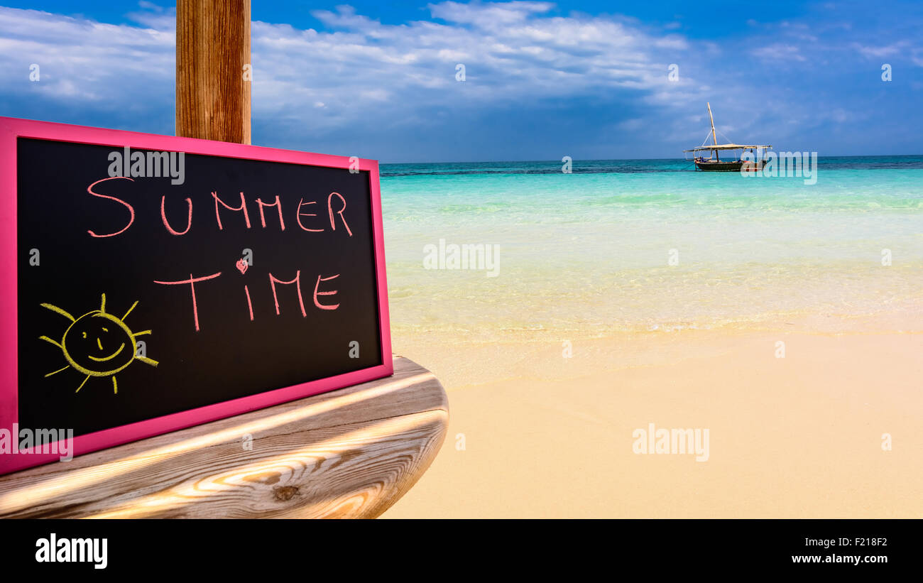 Auf dem Bild ein Zanzibar beach ist eine kleine Tafel mit den Worten "Sommerzeit" am Nachmittag. Stockfoto