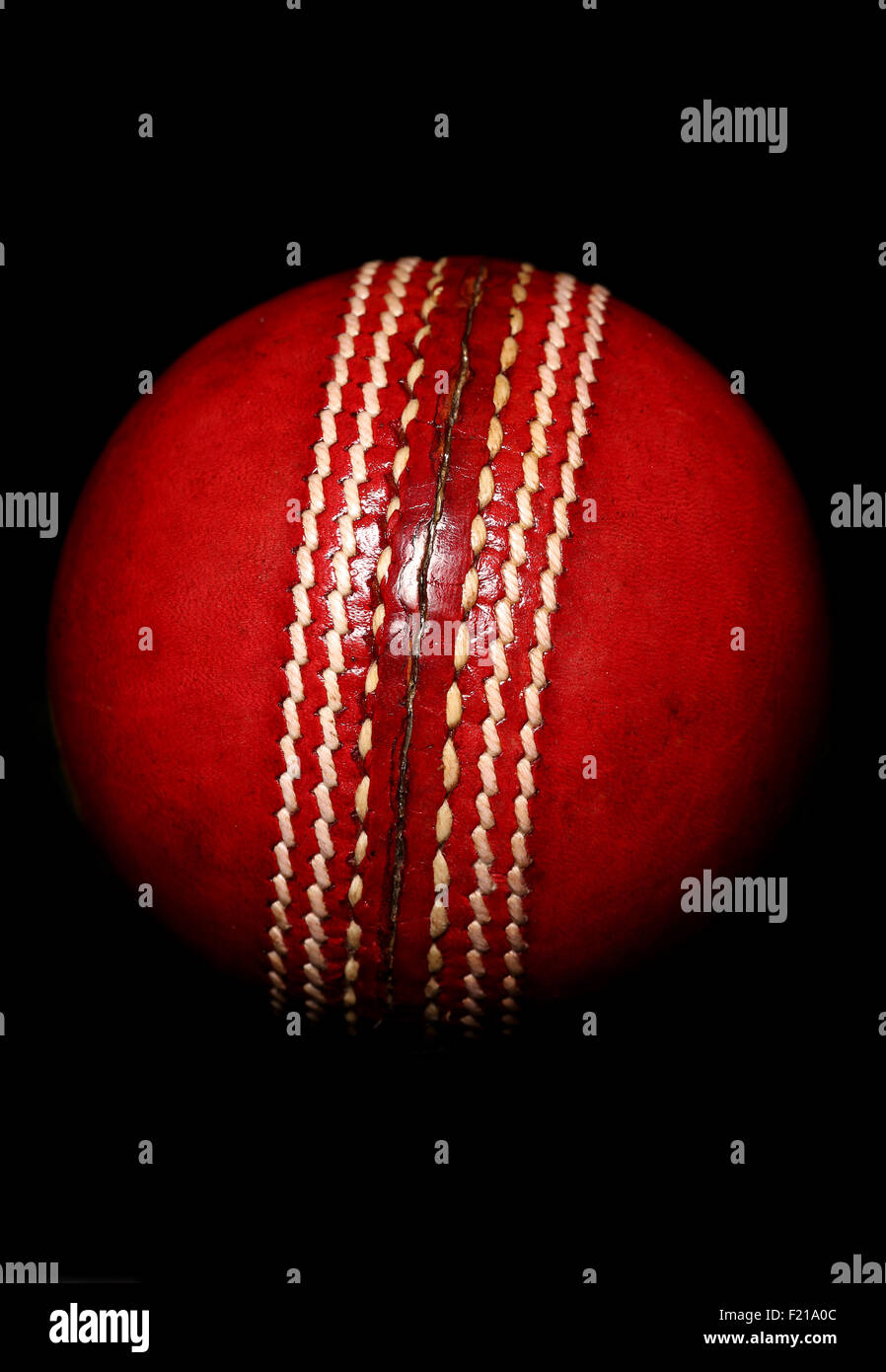 roten Cricketball auf schwarzem Hintergrund Stockfoto