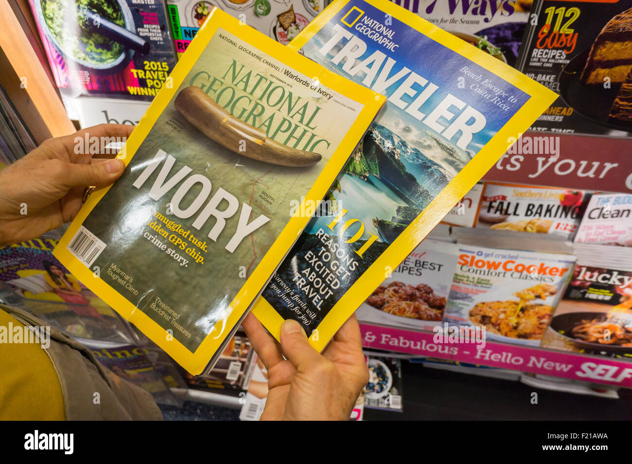 Ein Leser mit Kopien von National Geographic und Nat Geo Reisende an einem Kiosk am Mittwoch, 9. September 2015 in New York. In eine Partnerschaft mit 21st Century Fox National Geographic Magazin ändert sich in gewinnorientierten Status mit Fox Zahlen $ 725 Millionen für einen Anteil von 73 % in der Non-Profit-National Geographic Society. Der Verkauf umfasst den Kabelkanal und die Gesellschaft der anderen Medien-Assets. (© Richard B. Levine) Stockfoto
