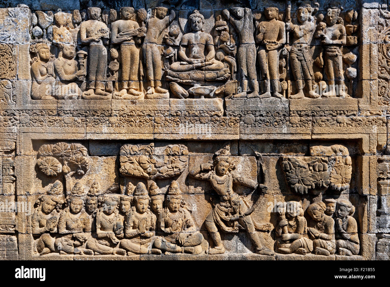 Indonesien Java Borobudur zwei-tiered Bas Relief zeigt sitzenden Buddha und Anhänger auf die oberste Stufe und Soldat oder König mit Bogen und Stockfoto