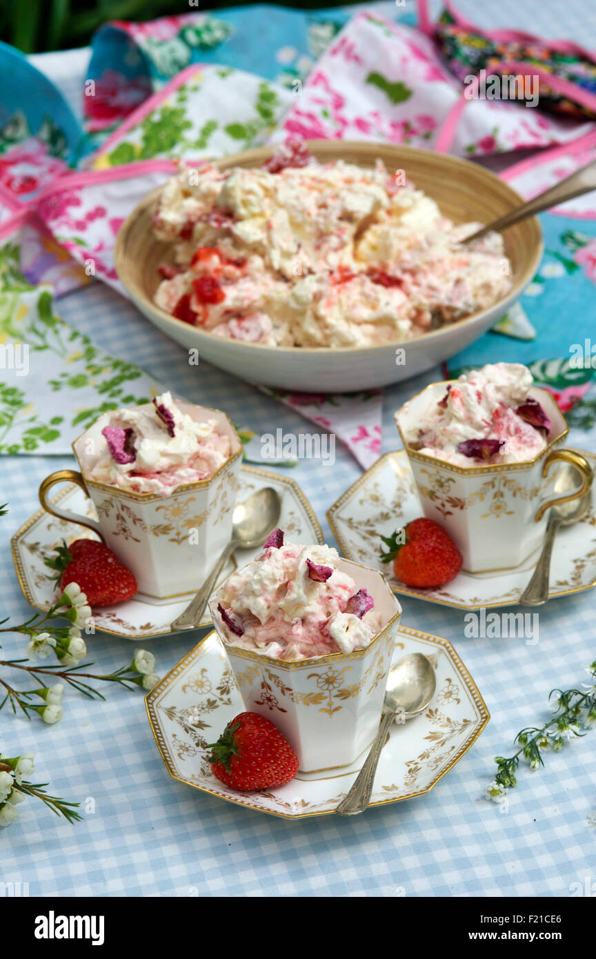Eton Chaos, ein traditionelles englisches Dessert mit Baiser, Sahne, Erdbeeren und hier in drei Porzellantassen serviert. eine UK Stockfoto