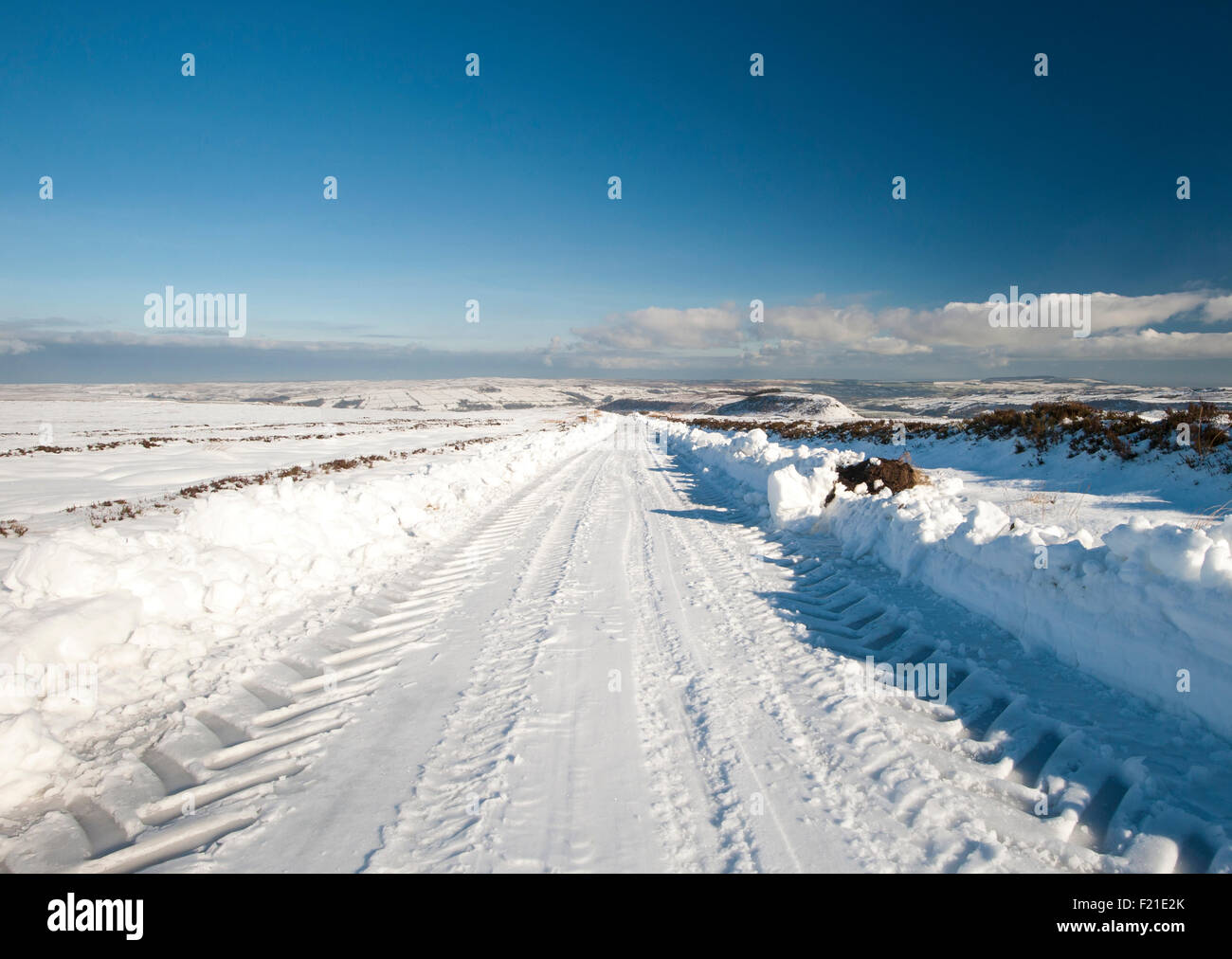 Verschneite Landstraße gehen in Ferne durch englische ländliche Winterszene Stockfoto