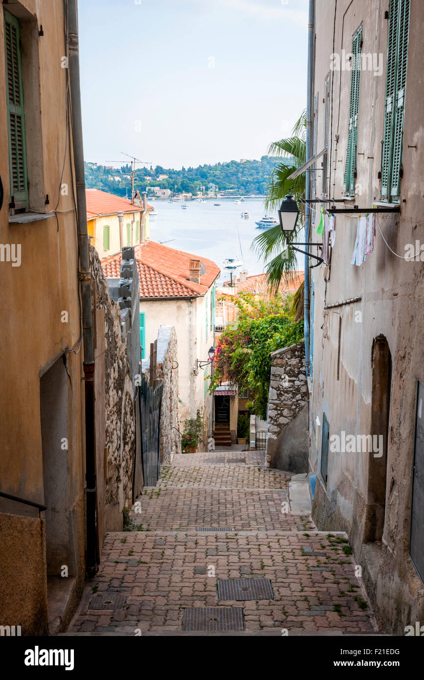 Schmale Straße mit alten Gebäuden führt zu Mittelmeer in der mittelalterlichen Stadt Villefranche-Sur-Mer an der Côte d ' Azur, Frankreich. Stockfoto