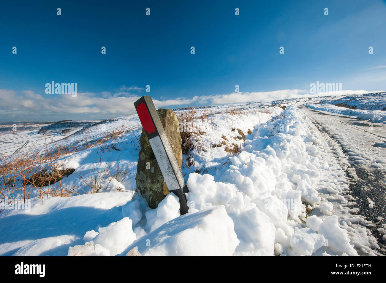 Verschneite Landstraße gehen in Ferne durch englische ländliche Winterszene Stockfoto