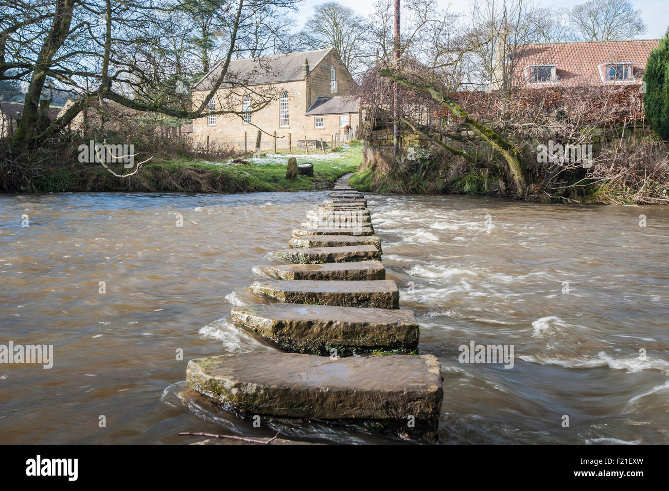 Trittsteine über einen kleinen Fluss im englischen Dorf Landschaft Szene. Stockfoto