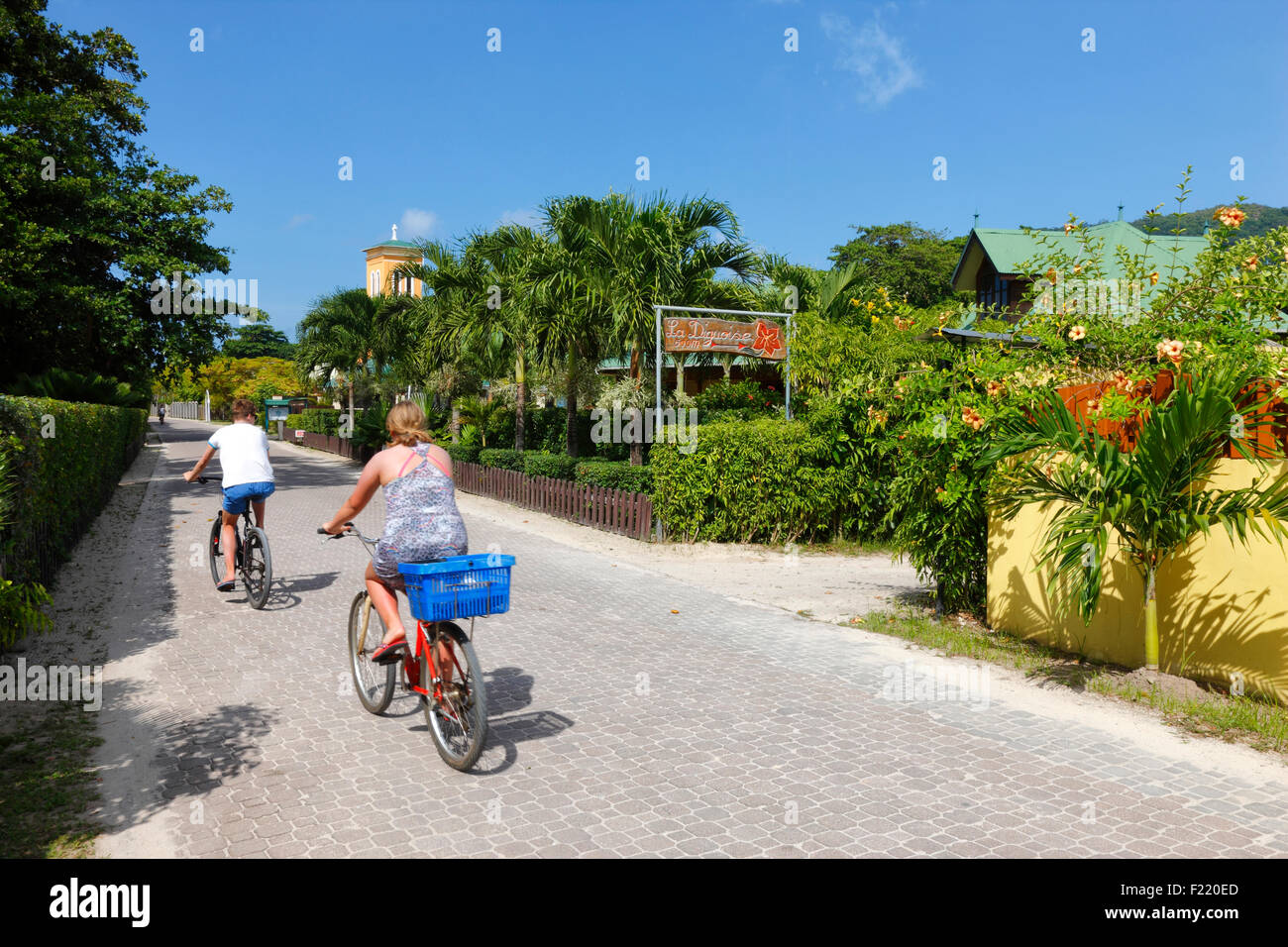 Touristen Driding ein Fahrrad auf die Straßen der Insel La Digue, Seychellen. Stockfoto
