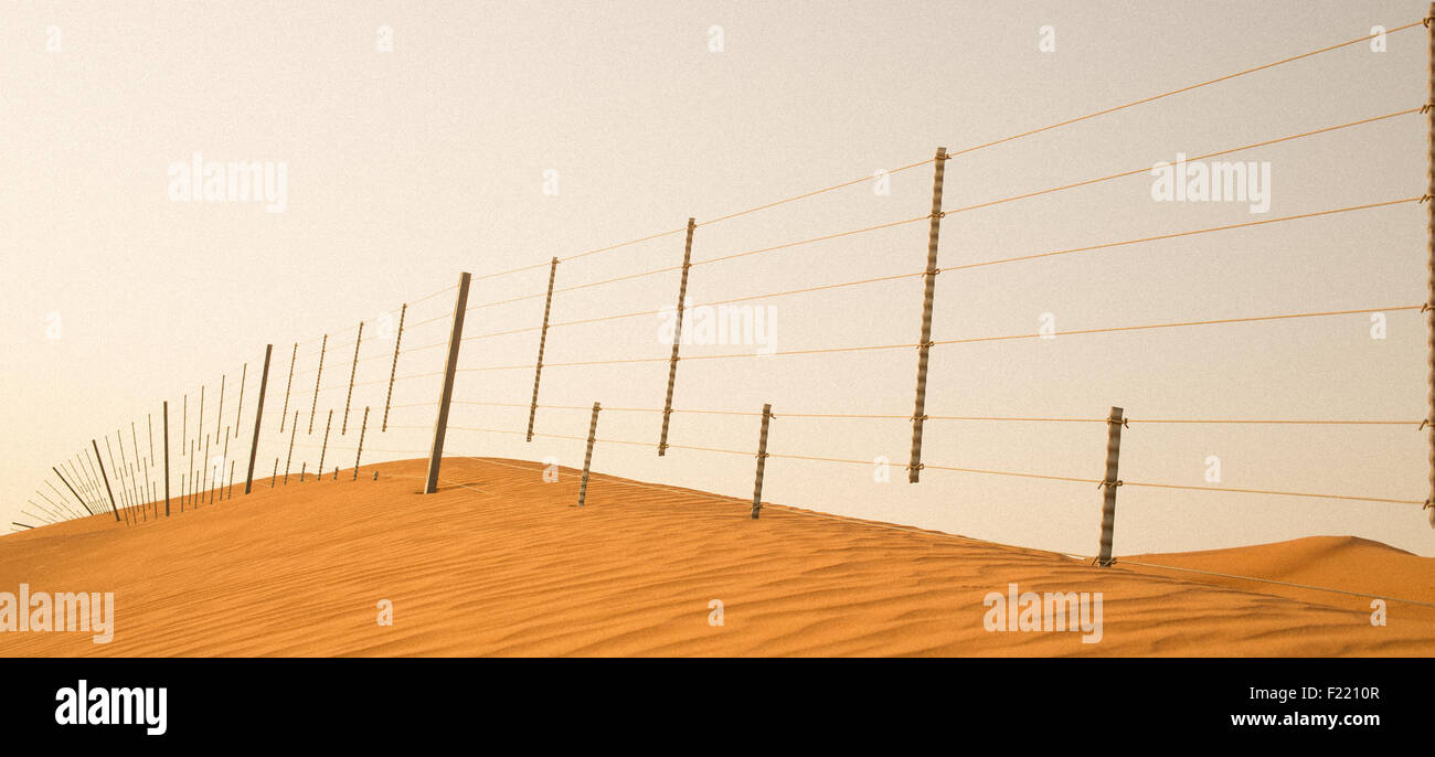 Ein Zaun, der Noten auf dem Kamm einer Sanddüne in den Vereinigten Arabischen Emiraten ähnelt Stockfoto