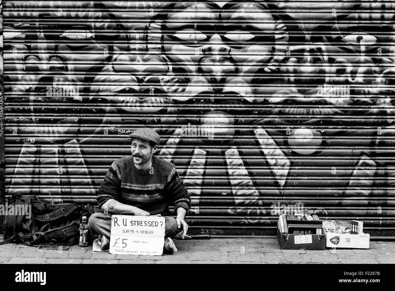 Ein Mann hält ein Schild fragt, ob Passanten zu schlagen, schlagen oder treten ihn zu entlasten, London, England Stockfoto