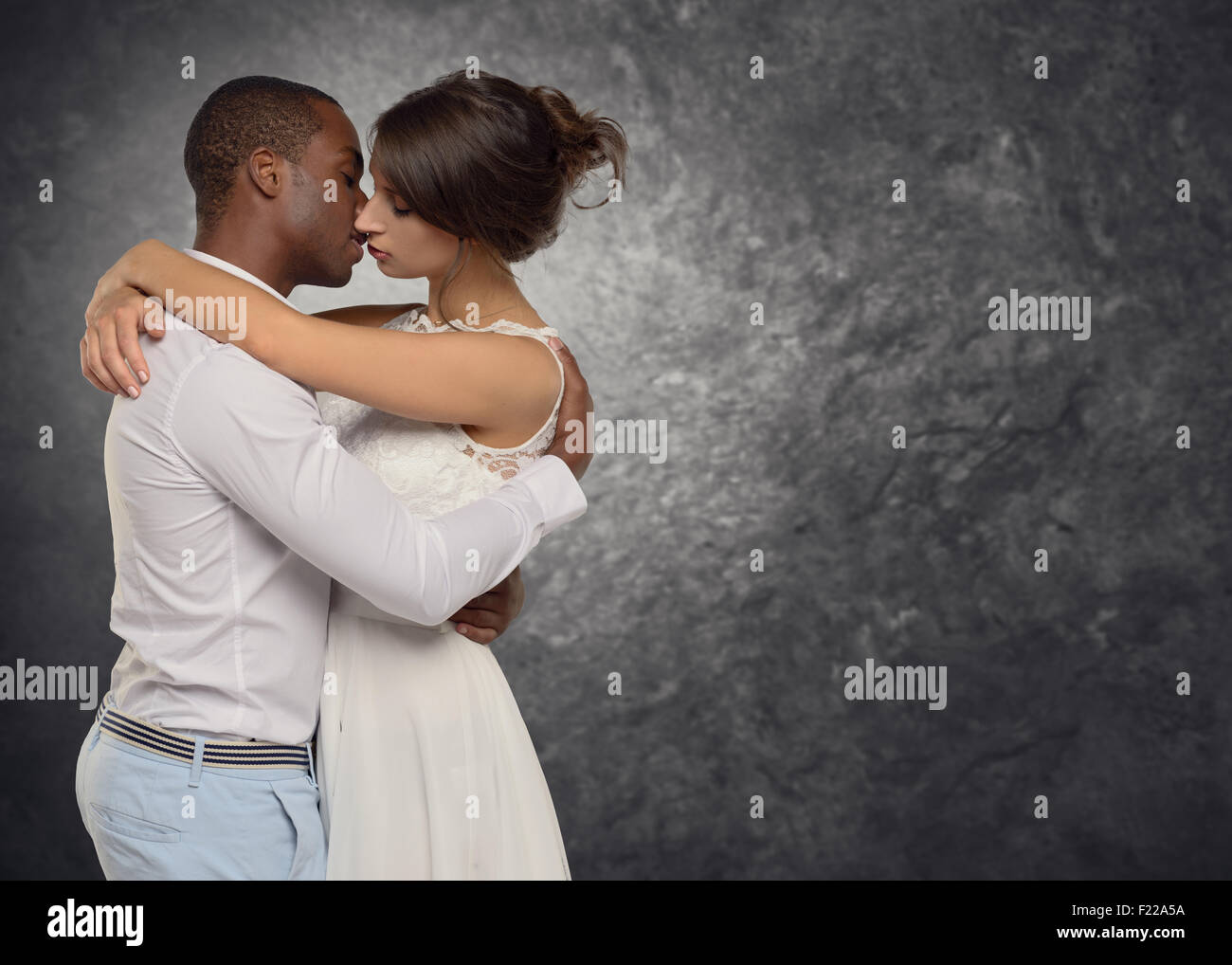 Junge Paar tief in Liebe zu umarmen und küssen sich leidenschaftlich in ein bewegender Moment, Seite Ansicht Oberkörper von wenigen Rassen Stockfoto