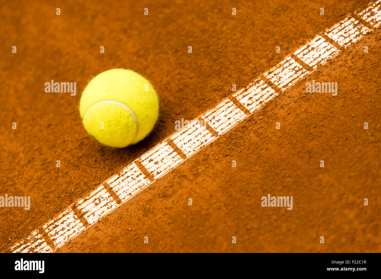 gelben Tennisball auf einem roten Sandplatz Stockfoto