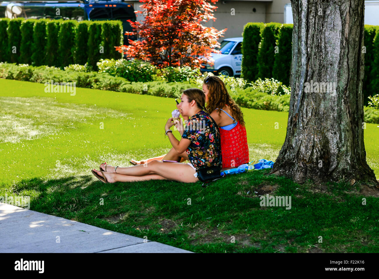 Zwei Studentinnen genießen die Sonne im Sommer und Eis in Coeur d ' Alene, Idaho Stockfoto