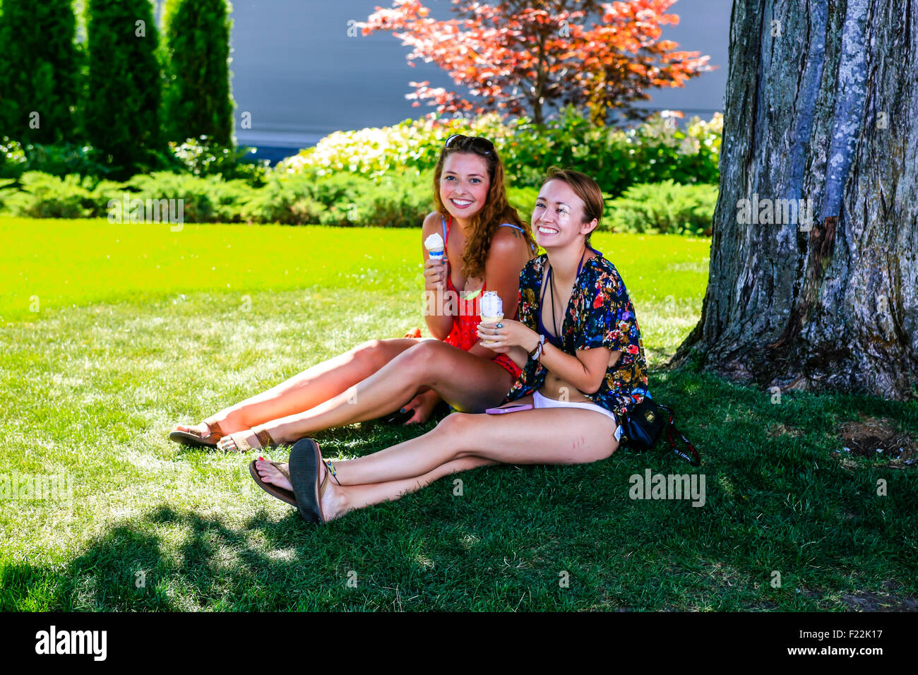 Zwei Studentinnen genießen die Sonne im Sommer und Eis in Coeur d ' Alene, Idaho Stockfoto