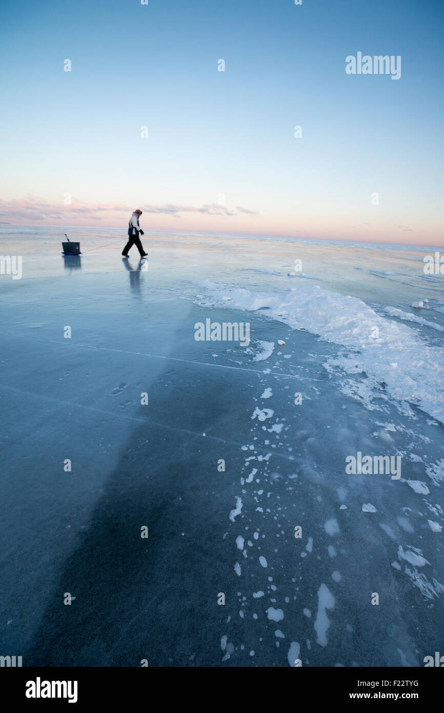 Person zu Fuß über gefrorenen Eis ziehen Kunststoff-Wanne auf einem Schlitten, Lake Superior, Apostel-Insel-Staatsangehöriger Lakeshore, WI Stockfoto