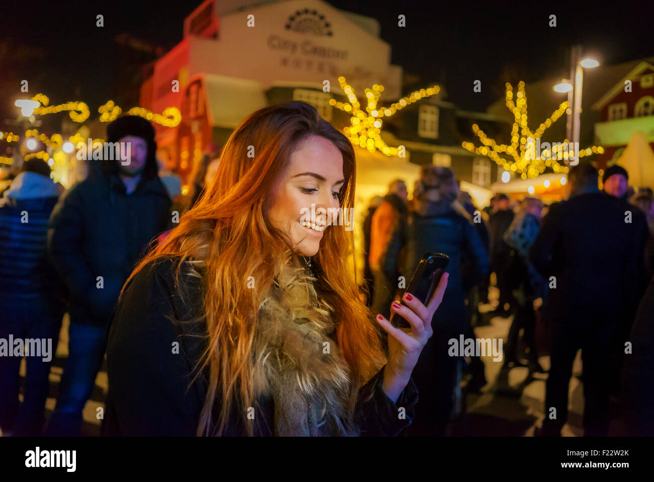 Frau, die an ihr Smartphone, Weihnachtsmarkt, Island Stockfoto