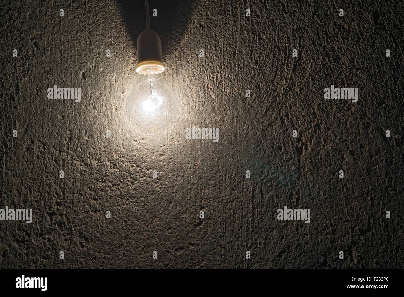 elektrische Glühlampe auf eine grobe Betonwand Stockfoto