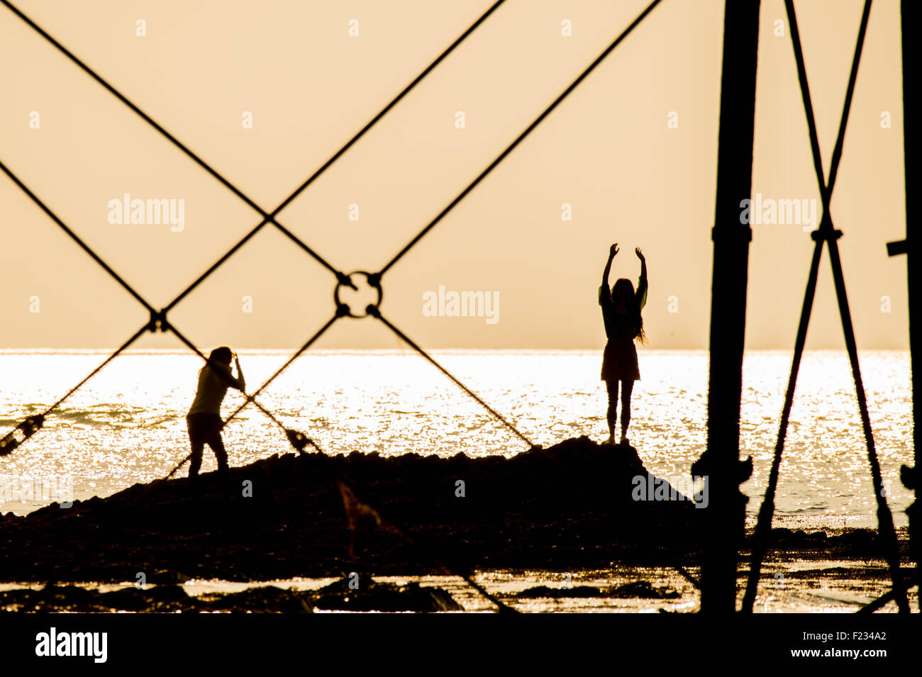 Aberystwyth Wales UK, Donnerstag, 10. September 2015 UK Wetter: die Sonne scheint in Aberystwyth an der Westküste von Wales als "Indian Summer" mit einem anderen Tag Sonnenstrahlen September weiter. Zwei Frauen sind Silhouette gegen das glitzernde Meer, wie sie gehen und am Meer Formen, eingerahmt von Gusseisen Beine von den viktorianischen Pier Photo Credit: Keith Morris / Alamy Live News Stockfoto