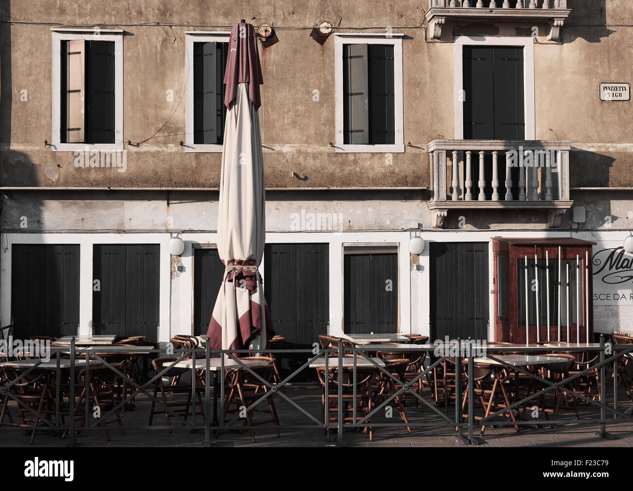 Tische, Stühle und Sonnenschirm außerhalb geschlossener Café Piazzetta Vigo Chioggia venezianischen Lagune Veneto Italien Europa Stockfoto