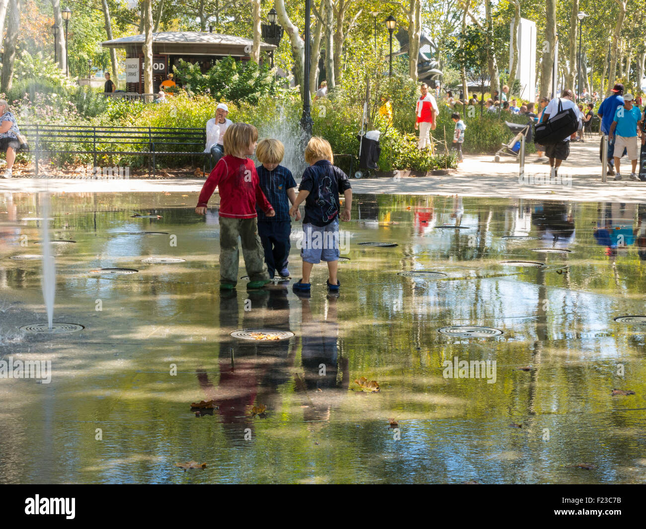 Junge Boys Spritzen in Bosque Brunnen im Battery Park, New York, USA Stockfoto