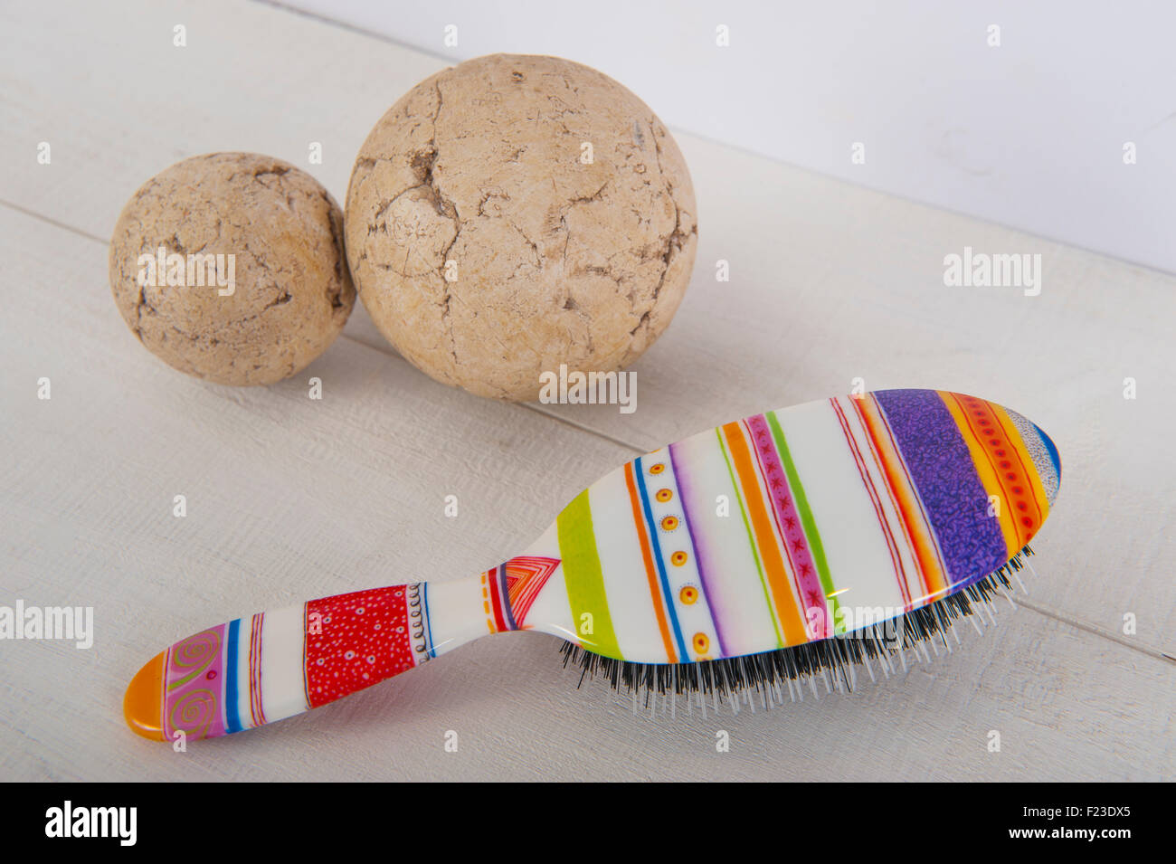 Einer bunten Haarbürste auf einem weißen Hintergrund mit zwei Kugeln Stockfoto