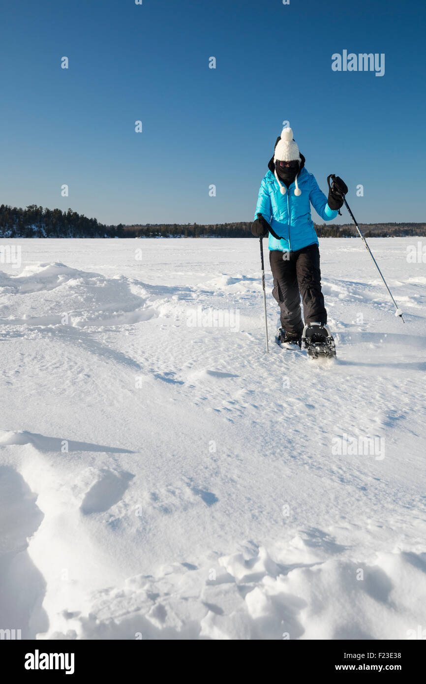 Erwachsene Frau Schneeschuhen über einen gefrorenen See in Ely, Minnesota auf einer kalten Minustemperaturen Temperatur Wintertag Stockfoto