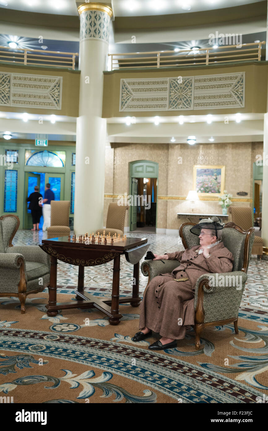 Ältere Frau Molly Brown darzustellen Überlebenden die Titanic sitzen in der Lobby des historischen West Baden Springs Res kostümiert Stockfoto