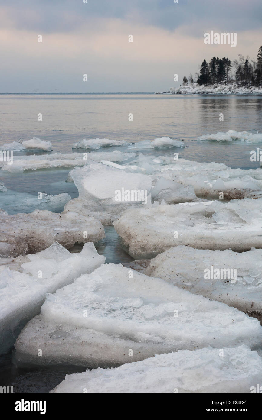 Weichen Pastell farbigen Sonnenaufgang über dem oberen See im Winter mit Eis und Eis der Platte schweben im Wasser, North Shore, MN Stockfoto