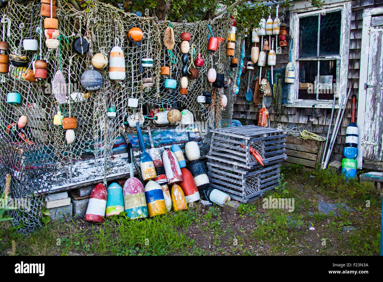Eine Sammlung von Liegeplatz, Kugeln und Schwimmer hing von einem Netz in einem Vorgarten einer Fischerei-Bude in Rockport Massachusetts Stockfoto