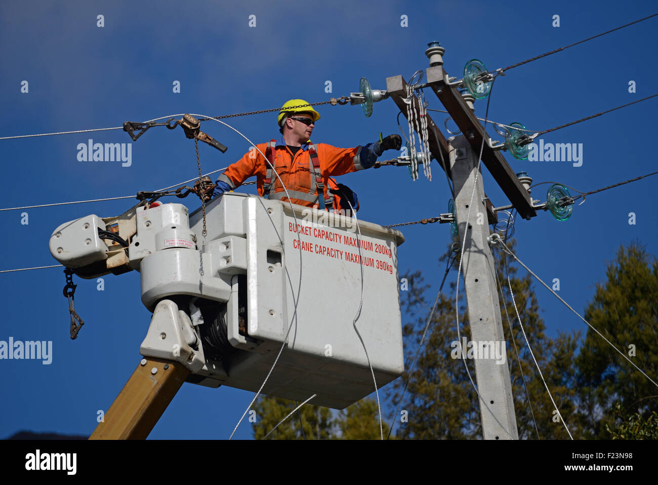 GREYMOUTH, Neuseeland, 5. August 2015: Linienrichter Draht oben ein Netz Stromversorgungskabel auf einen neuen Pfosten Stockfoto