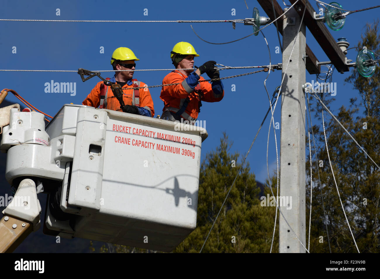 GREYMOUTH, Neuseeland, 5. August 2015: Linienrichter Draht oben ein Netz Stromversorgungskabel auf einen neuen Pfosten Stockfoto