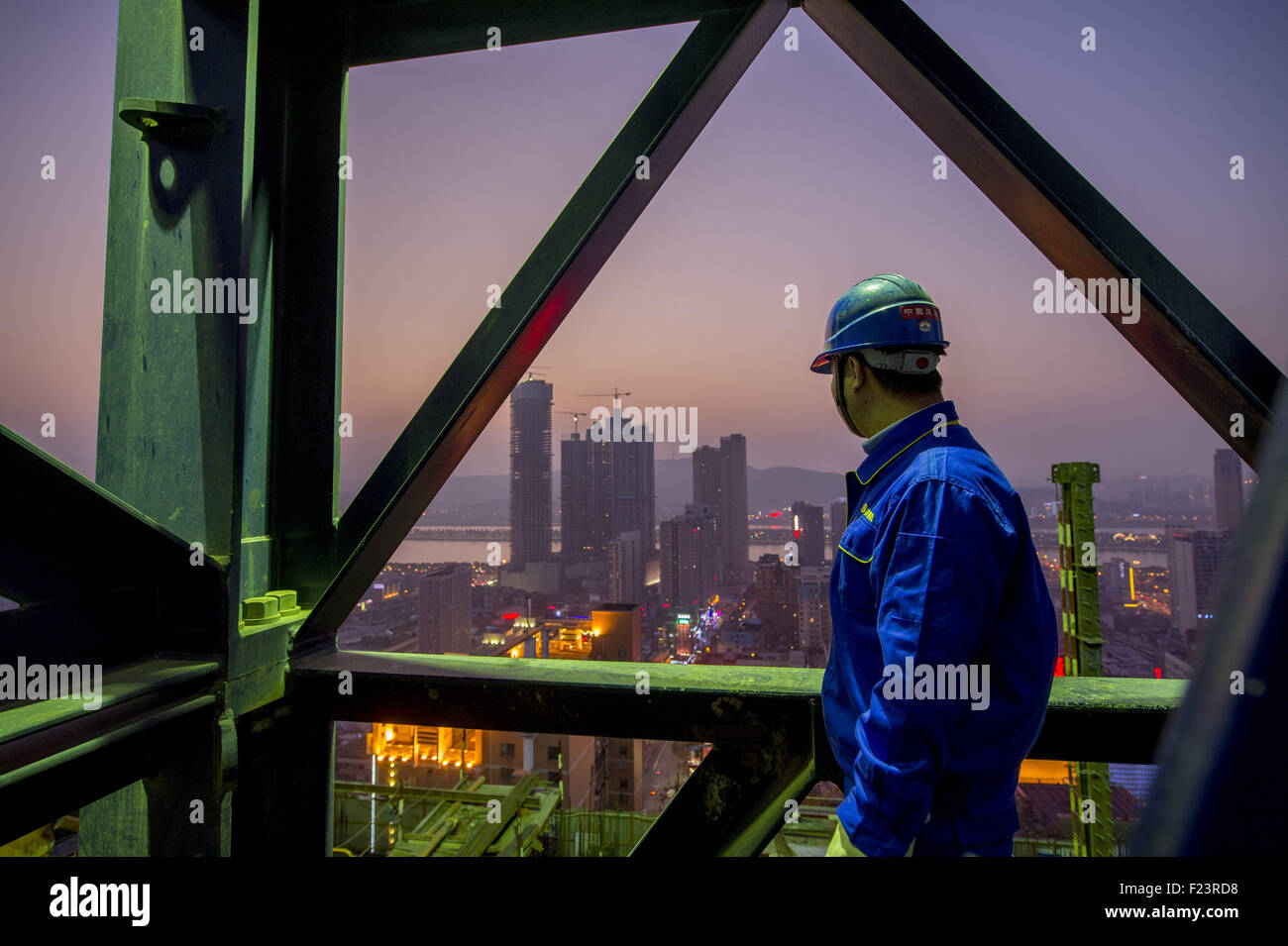 Changsha, Hunan, CHN. 21. Januar 2015. Changsha, CHINA - 21. Januar 2015: (Nur zur redaktionellen Verwendung. CHINA aus) Changsha International Finance Center entsteht auf 452 Meter und 136 Meter hohen Turm Kranführer Pan Linhai aus Hubei arbeitet auf dem höchsten Punkt in Hunan. Um solche Skycraper zu bauen, alle konkreten Eisen- und Stahlkonstruktionen durch ein Turmdrehkran vom Boden in die Luft transportiert werden müssen. ZSL2700 und ZSL750 laufen sowohl im T1 Tower und Pan betreibt die größte eins in Hunan, die zweitgrößte des Landes, ZSL2700. Pan aufsteht am 05:30 am Tagschicht. Pan und seine Kollegen Stockfoto