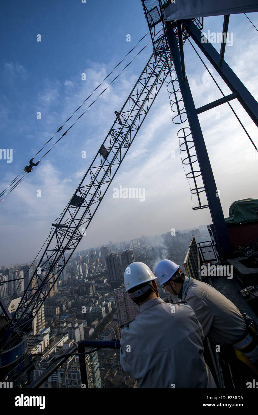 Changsha, Hunan, CHN. 21. Januar 2015. Changsha, CHINA - 21. Januar 2015: (Nur zur redaktionellen Verwendung. CHINA aus) Changsha International Finance Center entsteht auf 452 Meter und 136 Meter hohen Turm Kranführer Pan Linhai aus Hubei arbeitet auf dem höchsten Punkt in Hunan. Um solche Skycraper zu bauen, alle konkreten Eisen- und Stahlkonstruktionen durch ein Turmdrehkran vom Boden in die Luft transportiert werden müssen. ZSL2700 und ZSL750 laufen sowohl im T1 Tower und Pan betreibt die größte eins in Hunan, die zweitgrößte des Landes, ZSL2700. Pan aufsteht am 05:30 am Tagschicht. Pan und seine Kollegen Stockfoto