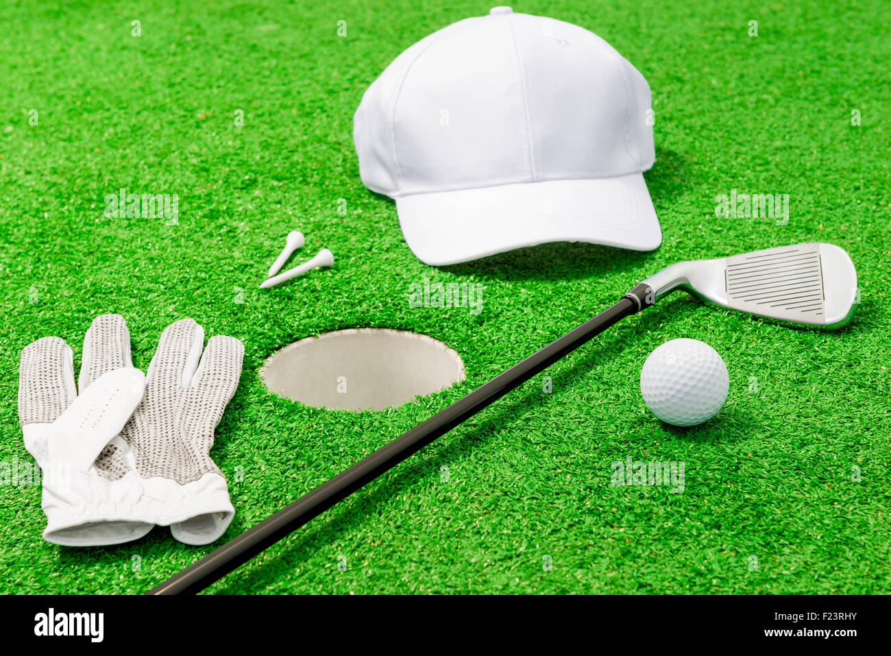Kleidung und Werkzeuge für das Golfspiel in der Nähe von das Loch auf dem Rasen Stockfoto