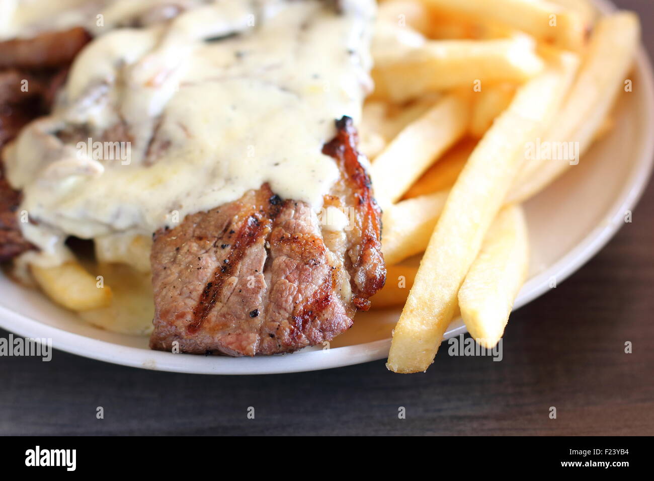 Steak und Chips mit cremiger Pilzsauce Stockfoto