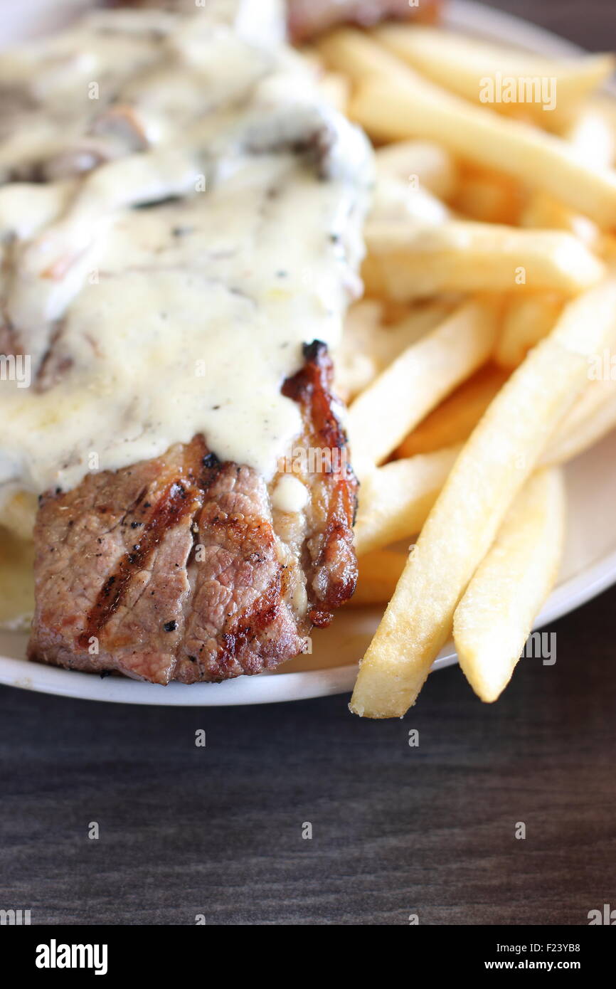 Steak und Chips mit cremiger Pilzsauce Stockfoto