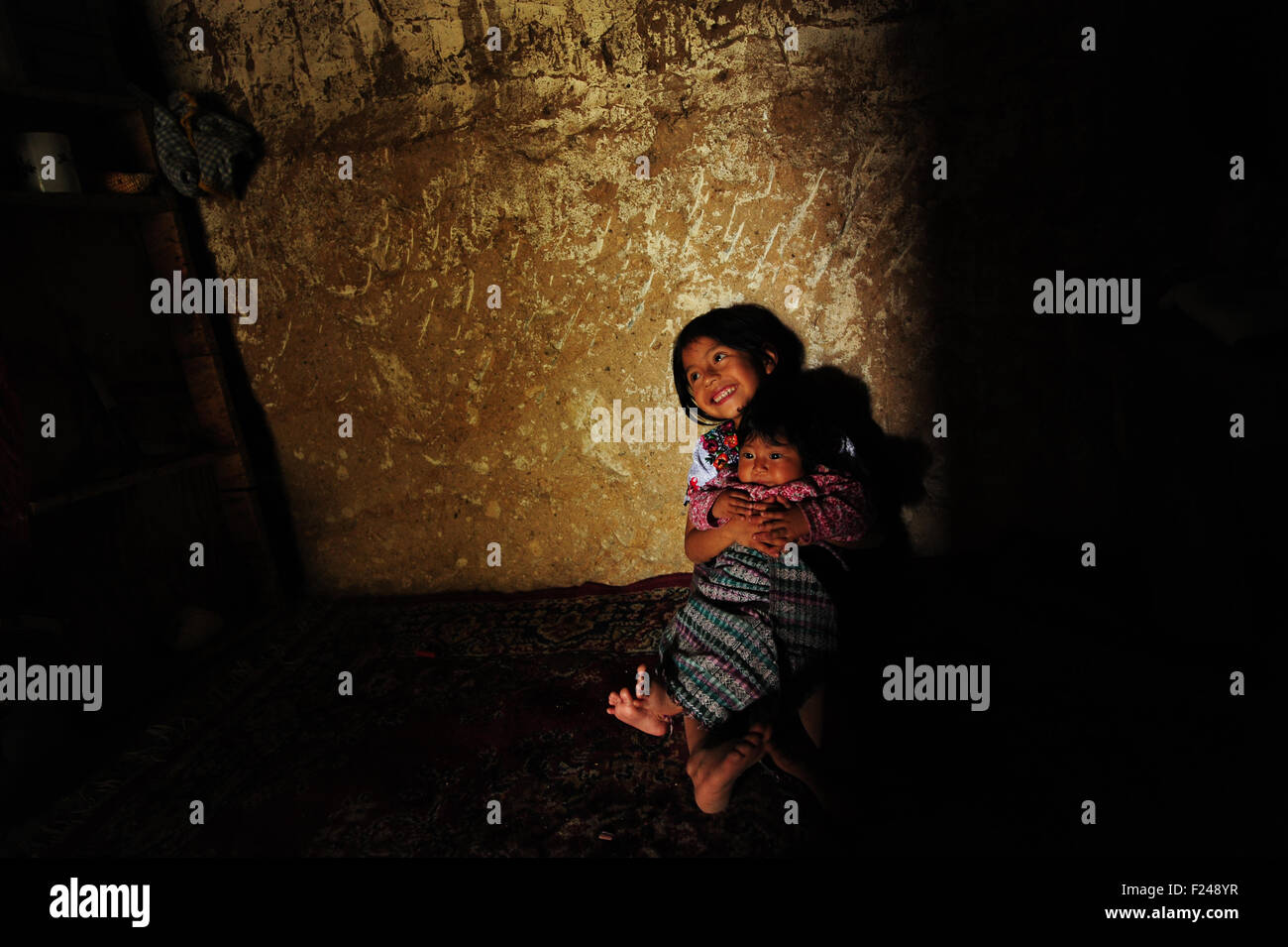 Guatemala, San Bartolo, Bruder und Schwester sitzen auf dem Boden im Inneren des Hauses (Luisa Maribel Torres Perez 5, Eleasar Usiel Torres Perez 3,5) Stockfoto