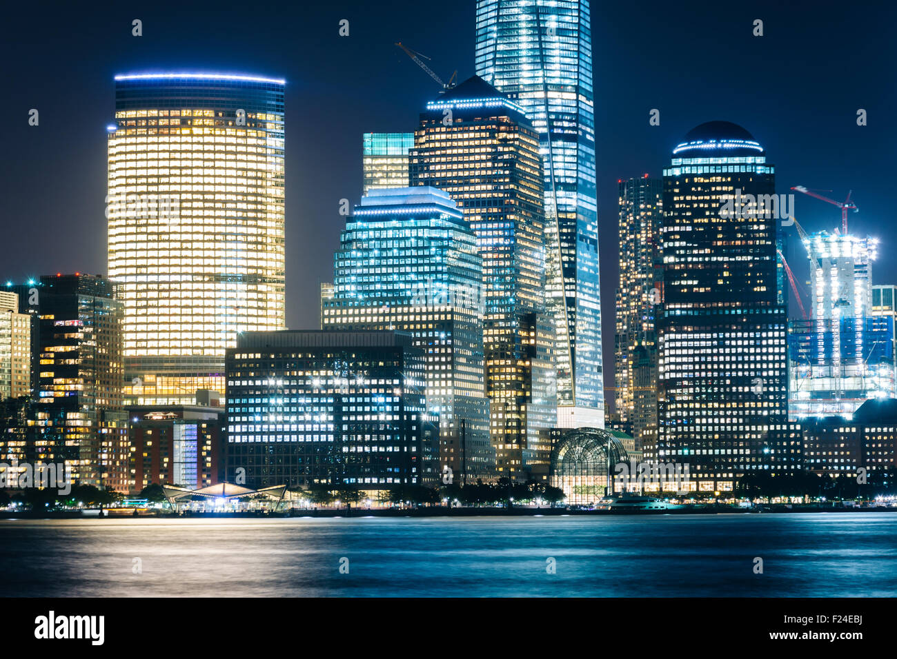 Blick auf die Lower Manhattan Skyline bei Nacht, von Exchange Place, in Jersey City, New Jersey. Stockfoto