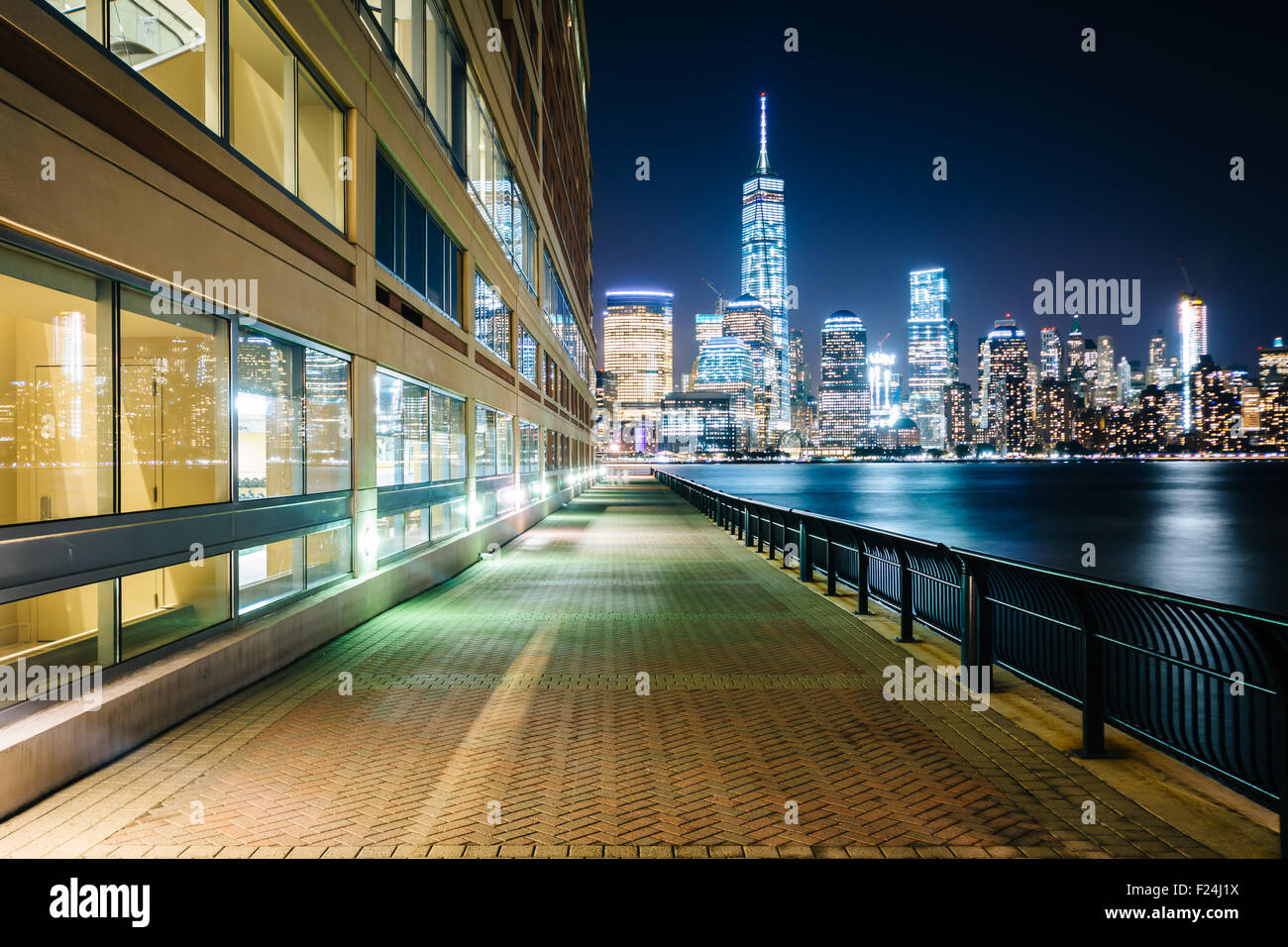 Waterfront Promenade und Blick auf die Skyline von Lower Manhattan in der Nacht, am Exchange Place in Jersey City, New Jersey. Stockfoto