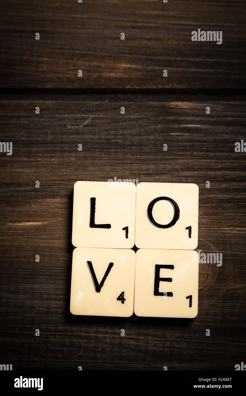 Liebe in Scrabble Buchstaben auf einem dunklen hölzernen