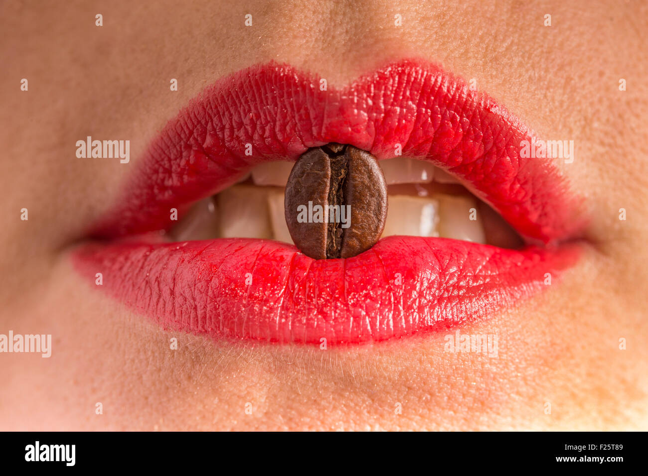 Kaffeebohne zwischen Lippen Stockfoto