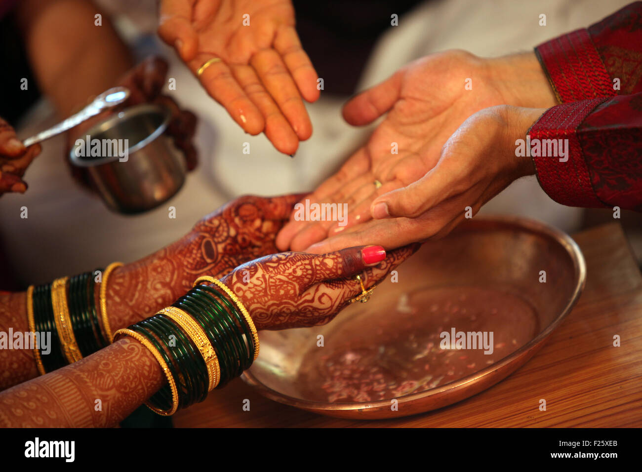 Die Hände der Braut und Bräutigam mit Weihwasser in einer traditionellen Hindu-Hochzeit Ritual gewaschen Stockfoto