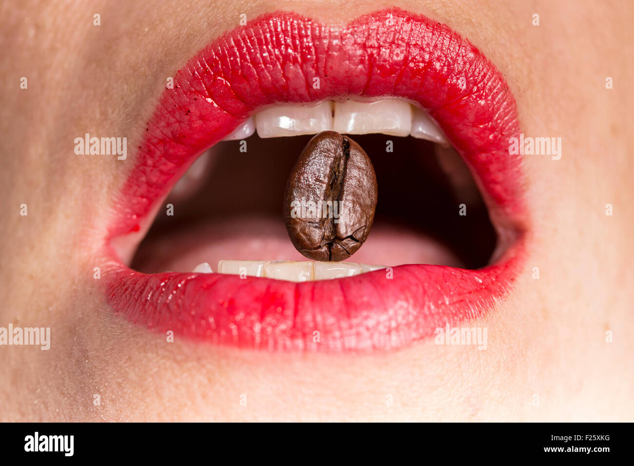 Kaffeebohne zwischen Lippen Stockfoto