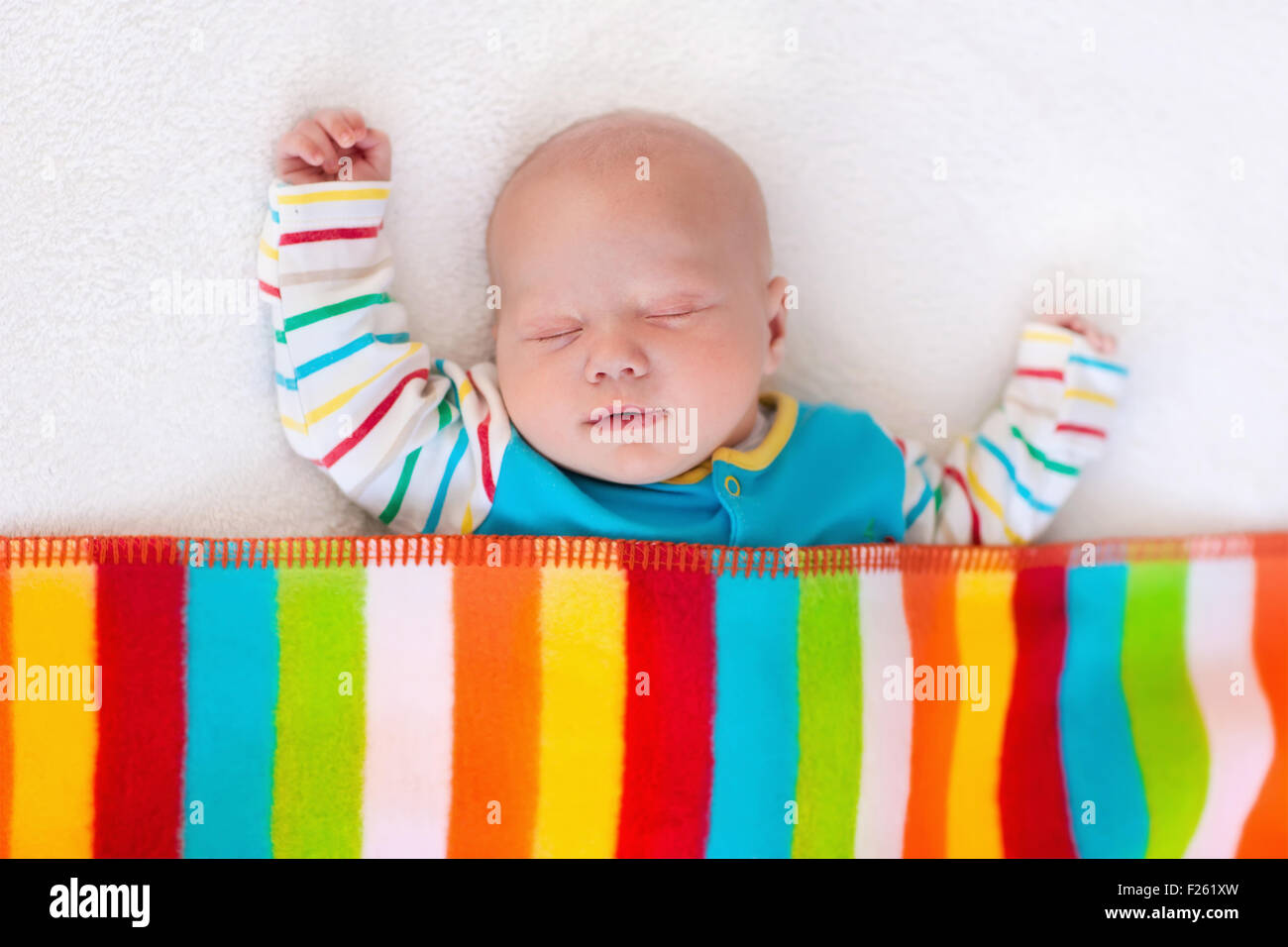 Neugeborenes Baby junge im Bett. Neues Kind geboren unter bunte Decke schlafen. Kinder schlafen